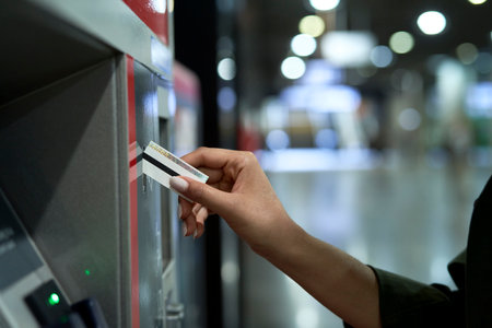 Hand of unrecognizable woman buying a ticket from the machine