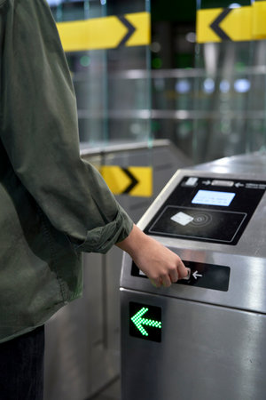 Unrecognizable woman putting ticket to the turnstile in the underground