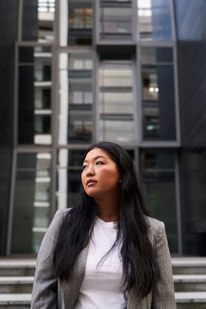Business Chinese woman standing on the street with building on the background
