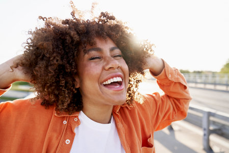 Very happy black woman in the street with eyes closedの写真素材