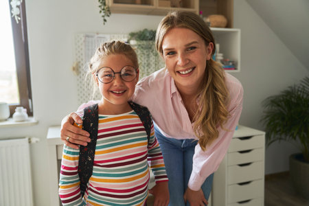 Portrait of caucasian woman and her daughter wearing schoolbagの写真素材