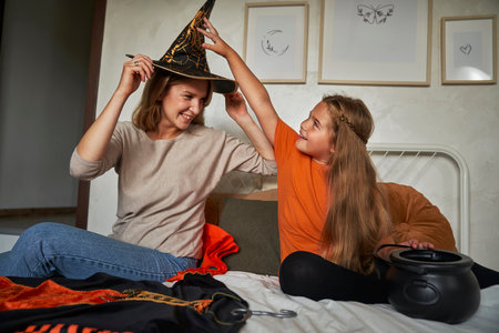 Caucasian mother and daughter preparing before Halloween party and having funの写真素材