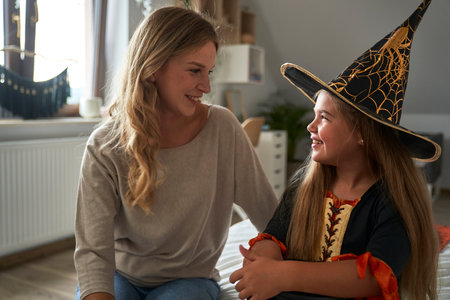 Caucasian mother and daughter bearing Halloween party costume
