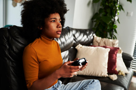Teenage girl playing video game in the living roomの写真素材