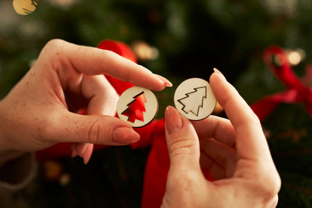 Human hands holding wooden Christmas decorationsの写真素材