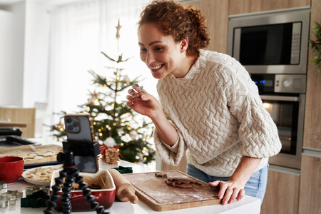 Caucasian woman preparing gingerbread cookies and recording a videoの写真素材