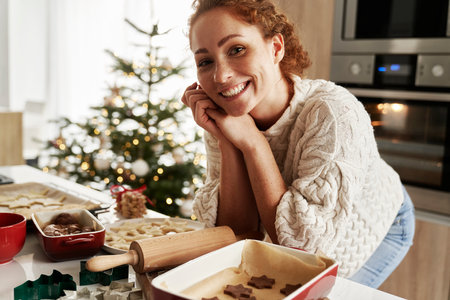 Portrait of caucasian woman preparing gingerbread cookies for Christmasの写真素材