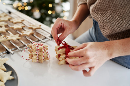 Unrecognizable woman preparing little gifts made of gingerbread cookiesの写真素材