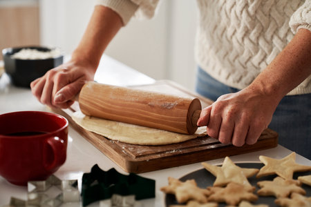 Unrecognizable woman using rolling pin to prepare dough for the Christmas cookiesの写真素材