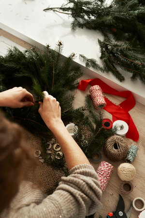High angle view of unrecognizable woman making a Christmas wreathの写真素材