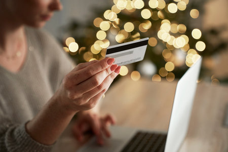 Young caucasian woman doing online shopping using mobile phone and digital laptopの写真素材