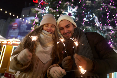 Caucasian couple with sparklers during New Years's party outdoorsの写真素材