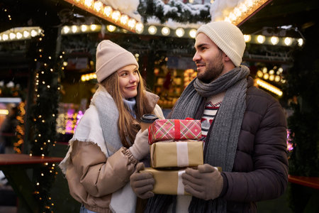 Caucasian couple on Christmas market with Christmas presentsの写真素材