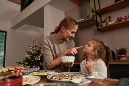 Mother and daughter having fun while decorating gingerbread cookiesの写真素材