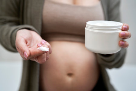 Pregnant woman holding a moisturizerの写真素材
