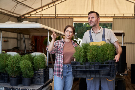 Two caucasian botanists working in greenhouse over plants seedlingの写真素材