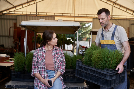 Two caucasian botanists working in greenhouse over plants seedlingの写真素材