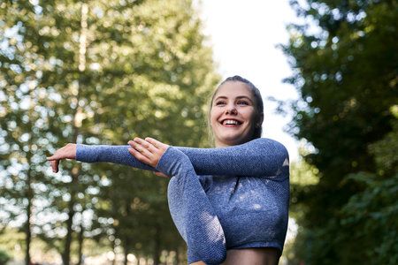 Young woman stretching before running in the parkの写真素材