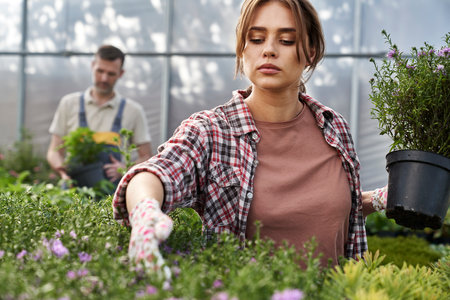 Two caucasian botanists working in greenhouse over flowersの写真素材