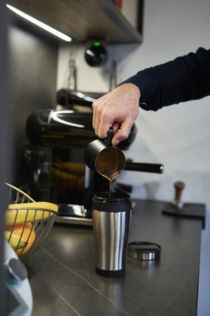 Man pouring homemade coffee into the travel mugの写真素材