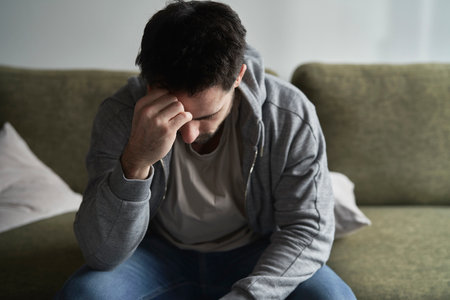 Broken man at home on sofaの写真素材