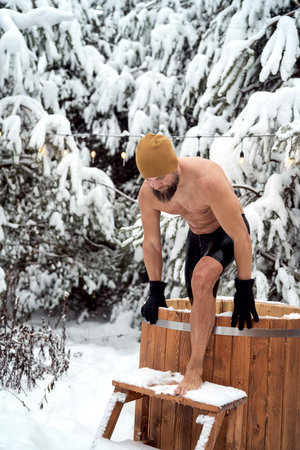 Caucasian man get out of the frozen water in winterの写真素材