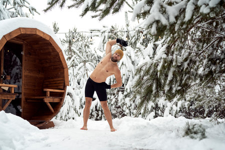 Caucasian man warming up before winter swim in barrelの写真素材