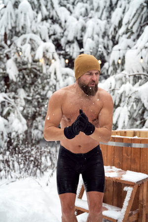 Caucasian man get out of the frozen water in winterの写真素材
