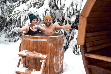 Caucasian couple enjoying the winter bath in tube outdoorsの写真素材