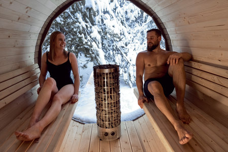Caucasian adult couple enjoying in the sauna in winterの写真素材