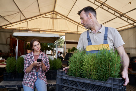Caucasian female botanist using mobile phone in the greenhouseの写真素材