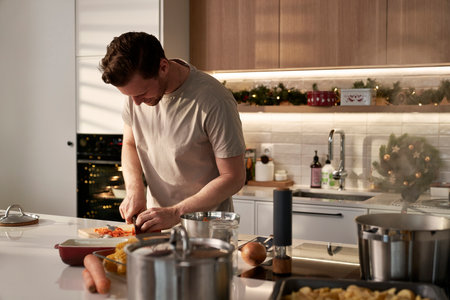 Caucasian man cutting vegetables food before Christmas cookingの写真素材