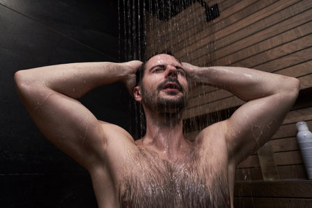 Caucasian man taking shower at homeの写真素材