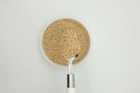 Sesame seeds in a bowl on a white backgroundの写真素材
