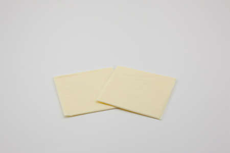 Sliced ââââcheddar cheese on a white backgroundの写真素材