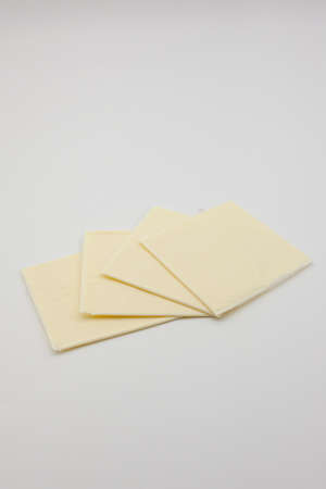 Sliced ââââcheddar cheese on a white backgroundの写真素材