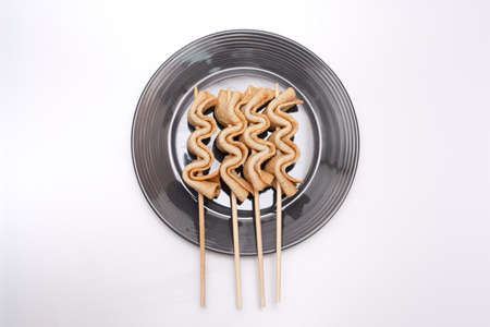 Fish cake skewers in a bowl on a white backgroundの写真素材