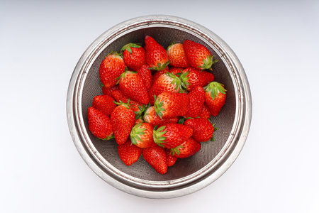 Fresh strawberries in a basket over white background