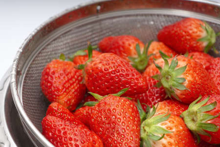 Fresh strawberries in a basket over white backgroundの写真素材