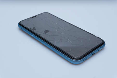 Smartphone with badly damaged screen on a white backgroundの写真素材