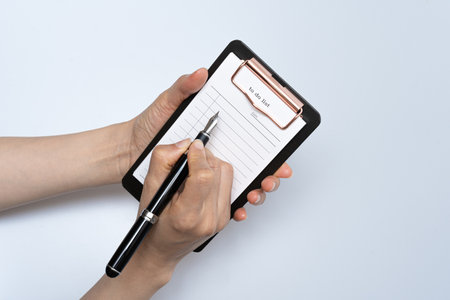 To-do list and fountain pen on a white backgroundの写真素材