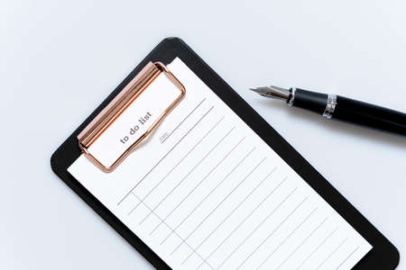 To-do list and fountain pen on a white backgroundの写真素材