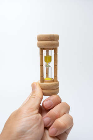 Hourglass held by an Asian on a white background