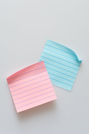 Various colored notepads scattered on a white backgroundの写真素材