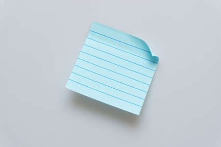 Various colored notepads scattered on a white backgroundの写真素材