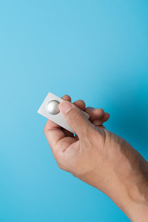 Individually wrapped pills on a blue backgroundの写真素材