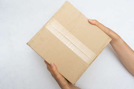 Unboxing the courier box with a cutter knifeの写真素材