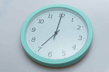 Wall clock showing various times on a white backgroundの写真素材