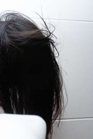 A woman drying her hair with a hair dryerの写真素材