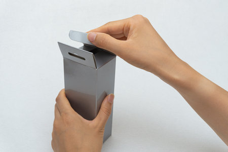 Unboxing the courier box with a cutter knifeの写真素材